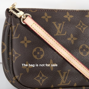 May include: Brown handbag with a repeating monogram pattern and a detachable strap. The bag features gold-tone hardware and a light-colored strap with red stitching. The text "The bag is not for sale" is visible on the bag.