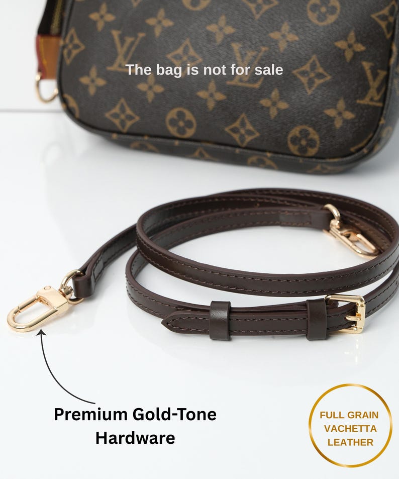 May include: A brown leather handbag strap with gold-tone hardware. The strap is made of full-grain vachetta leather and features a buckle and clasp. The bag is not for sale.