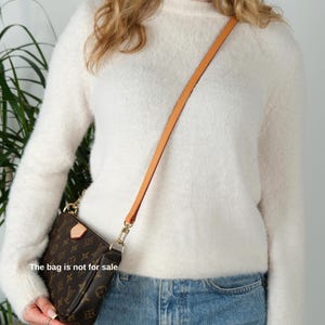 May include: Brown and tan crossbody bag with a gold chain and a tan leather strap. The bag features a repeating pattern of brown logos. The text "The bag is not for sale" is visible on the image.