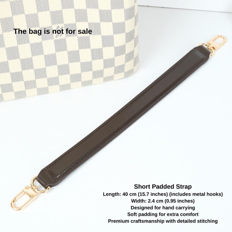 May include: A brown leather strap with gold metal hooks. The strap is 15.7 inches long and 0.95 inches wide. It is designed for hand carrying and has soft padding for extra comfort. The strap is made with premium craftsmanship and detailed stitching.