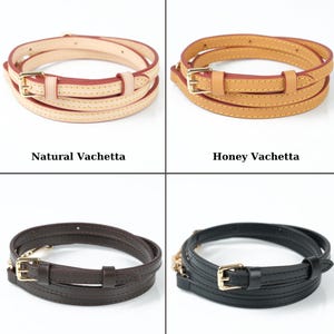 May include: Four leather bag straps in various colours: natural, honey, brown, and black. Each strap is coiled and has a gold-tone buckle. The text "Natural Vachetta", "Honey Vachetta", "Brown Vachetta", and "Black Vachetta" is below each strap.