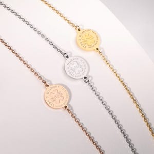 May include: Three medical alert bracelets in gold, silver, and rose gold. Each bracelet has a circular pendant with the medical symbol and the text "Diabetic Type 2 ICE: 000-0000". The bracelets are displayed on a white surface.
