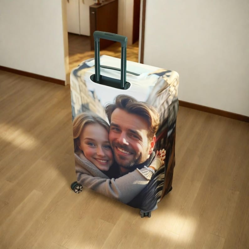 May include: A luggage cover with a photo of a couple smiling and hugging. The cover is white with a black handle.