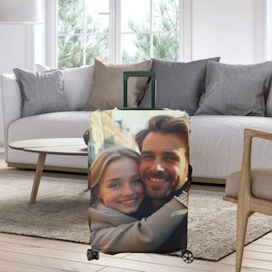May include: A luggage cover with a photo of a man and a girl hugging. The photo is printed on a white background.