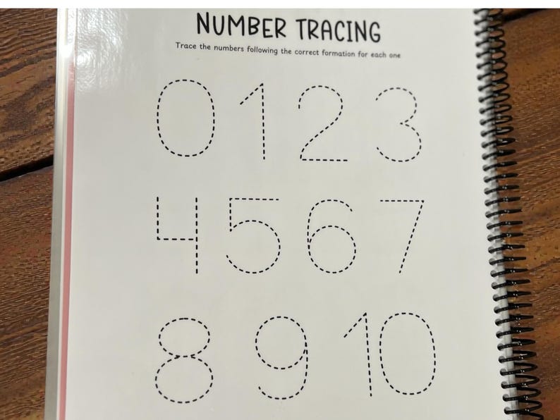 May include: A spiral-bound workbook page with the title "NUMBER TRACING." The page displays numbers 0 through 10 in dotted lines for tracing. The text "Trace the numbers following the correct formation for each one" is above the numbers.
