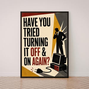 May include: A framed poster featuring a silhouette of a person in a suit standing next to a vintage computer tower and monitor. The text reads, HAVE YOU TRIED TURNING IT OFF & ON AGAIN? The design uses a palette of black, red, yellow, and cream.
