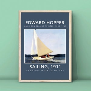 Op de afbeelding: Een ingelijste print van een schilderij van Edward Hopper, een Amerikaanse realistische schilder, getiteld "Sailing, 1911". Het schilderij toont een zeilboot met een witte zeil op een blauwe watermassa onder een lichtblauwe lucht. De print is afkomstig uit het Carnegie Museum of Art.