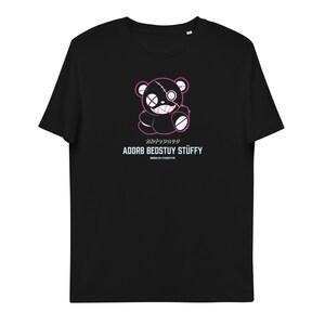 Op de afbeelding: Zwart T-shirt met een roze omtrek van een gestikte teddybeer met een ondeugende grijns. De tekst "カルチャーショック" en "ADORB BEDSTUY STUFFY" staat onder de beer gedrukt.