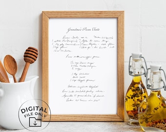 May include: A framed print featuring a handwritten recipe titled Grandma's Pecan Tarts in black ink on white paper. The light wood frame is centered between a white pitcher with wooden utensils and two glass bottles filled with oil and spices.