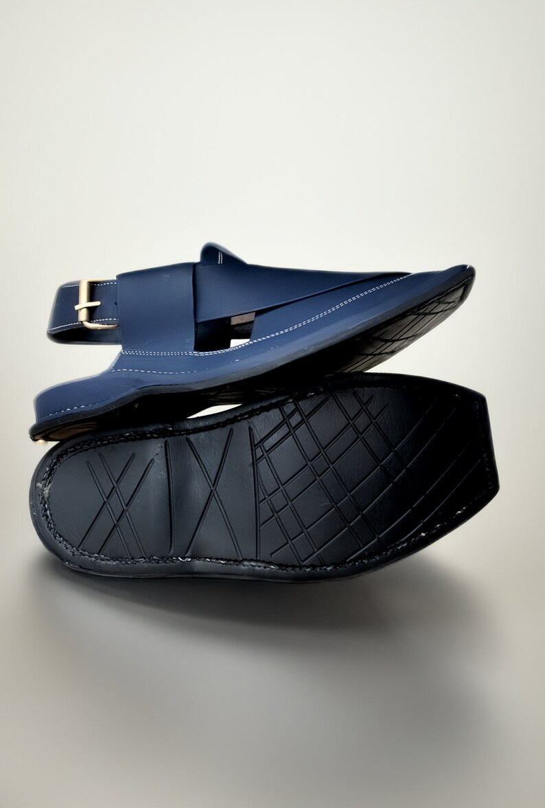 May include: A pair of dark blue leather sandals with a buckle strap and a textured black sole.