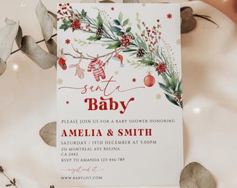 May include: A Christmas-themed baby shower invitation with a watercolor illustration of a wreath with red berries, pine cones, and greenery. The text reads "santa Baby" and includes details for the event, including the date, time, location, and RSVP information.