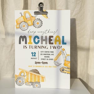 Puede incluir: Una invitación de cumpleaños de vehículo de construcción amarillo y azul con el texto "dump everything! MICHEAL IS TURNING TWO!" La invitación incluye la fecha "12 AUGUST" y la hora "2pm-5pm".