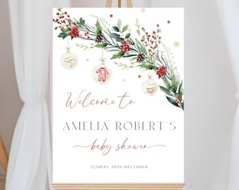 Può includere: Un cartello di benvenuto bianco con una ghirlanda acquerellata rossa e verde con ornamenti. Il testo recita "Benvenuti al Baby Shower di Amelia Robert Domenica 20 dicembre".