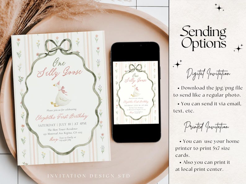 May include: A birthday invitation with a whimsical design featuring a goose wearing a pink bow. The invitation includes the text "One Silly Goose" and event details. A smartphone displays the same invitation. The invitation is on a decorative tray.