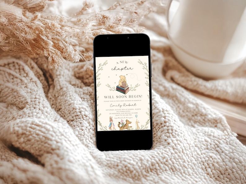 May include: A Winnie the Pooh themed baby shower invitation on a smartphone screen. The invitation features a cartoon illustration of Winnie the Pooh sitting on a stack of books with the text "A new chapter will soon begin!" and the name "Emily Robert".