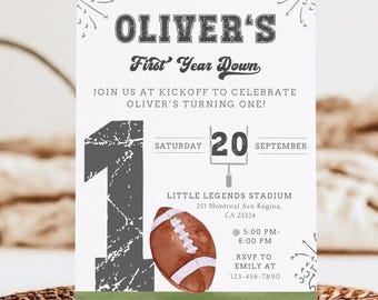 May include: A white and gray football-themed invitation for a first birthday party. The invitation features a large number "1" with a football and a scoreboard with the number "20" for the date. The text reads "Oliver's First Year Down" and includes the date, time, and location of the party.
