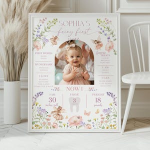 May include: A framed photo with a baby girl in a pink dress, surrounded by floral and fairy illustrations. The text reads "Sophia's fairy first year." The baby is 30 inches tall and weighs 18 pounds.