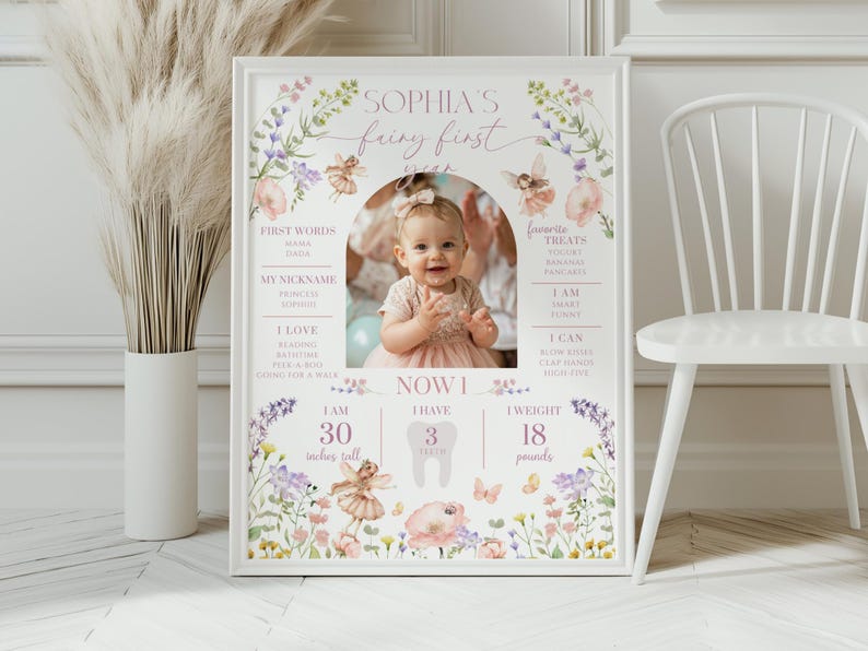 May include: A framed photo with a baby girl in a pink dress, surrounded by floral and fairy illustrations. The text reads "Sophia's fairy first year." The baby is 30 inches tall and weighs 18 pounds.