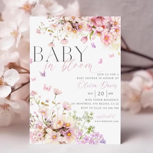 May include: A baby shower invitation with a floral design. The invitation says "Baby in Bloom" and includes the name "Olivia Davis". The date of the shower is November 20th at 6 PM. The location is Ikon Tower Residence, 251 Montreal Ave Regina, CA 22. RSVP to Ellie at 123-456-789. The invitation also includes the website "www.babylist.com".