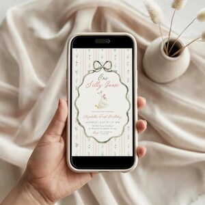 May include: A smartphone displays a digital invitation with the text "One Silly Goose" and details for a first birthday celebration. The design features a goose illustration, a bow, and a floral background.