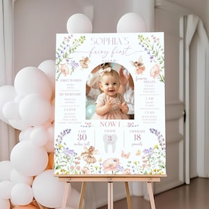 May include: A personalized first birthday sign featuring a photo of a baby girl. The sign includes the text "Sophia's Fairy First" with floral and fairy illustrations. The sign indicates the baby is 30 inches tall and weighs 18 pounds.