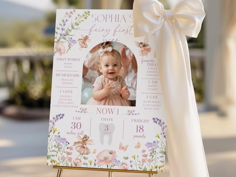 Pode incluir: Um letreiro personalizado para o primeiro anivers&aacute;rio, com uma foto de uma menina. O letreiro inclui o texto "Sophia's Fairy First Year" com ilustra&ccedil;&otilde;es florais e de fadas. O beb&eacute; mede 76 cm e pesa 8,2 kg.
