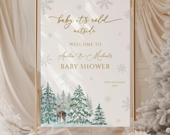 May include: A framed baby shower sign with a winter theme. The sign reads "baby it's cold outside" and welcomes guests to Amelia & Michael's baby shower on December 11th, 2025. The design includes snowflakes, a deer, and snow-covered trees.