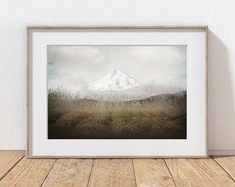 May include: A framed photograph of a snow-capped mountain peak rising above a field of tall grass. The mountain is partially obscured by clouds, creating a soft, ethereal atmosphere.