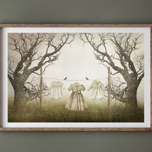 May include: A framed illustration of three dresses hanging on a clothesline between two bare trees. The dresses are white, green, and white. Two small birds are perched on the clothesline.