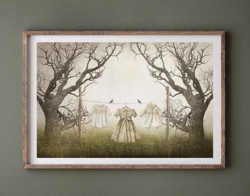 May include: A framed illustration of three dresses hanging on a clothesline between two bare trees. The dresses are white, green, and white. Two small birds are perched on the clothesline.