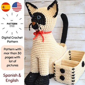 May include: A crocheted Siamese cat with a matching basket. The cat is cream-colored with black accents, blue eyes, and a red collar. The basket is cream-colored with black spots and stitching. The image includes text that says "Digital Crochet Pattern".
