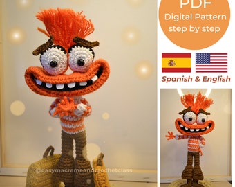 Puede incluir: Un patrón de crochet para un personaje de dibujos animados con pelo naranja, labios rojos y una camisa a rayas. El patrón está disponible en español e inglés e incluye 20 páginas con imágenes y un video.