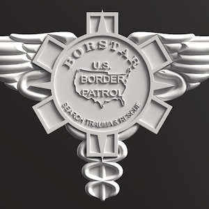 May include: A silver-colored emblem with wings, a central starburst design, and the text "BORSTAR U.S. BORDER PATROL SEARCH TRAUMA & RESCUE." The emblem features a caduceus symbol at the bottom.