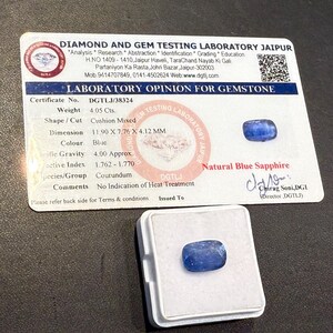 Puede incluir: Un zafiro azul con talla mixta coj&iacute;n, con un peso de 4,05 quilates. La gema se muestra en una caja blanca junto a un certificado de laboratorio. El certificado proporciona detalles, incluidas las dimensiones de 11,90 x 7,76 x 4,12 mm.