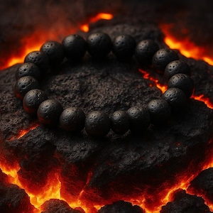 May include: A black lava stone bracelet with a circular design. The bracelet is composed of round, porous beads. The bracelet rests on a dark, textured rock formation with a fiery, orange-red glow in the background, creating a dramatic contrast.