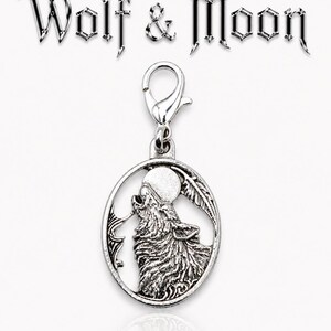 May include: Silver-toned charm with a howling wolf silhouette, a full moon, and a feather design within an oval frame. The charm is attached to a clasp. The words "Wolf & Moon" are above the charm.