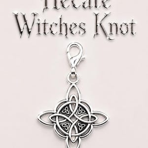 May include: A silver-colored charm with a Celtic knot design, featuring a lobster clasp for attachment. The charm is in the shape of a four-pointed star with an intricate knot pattern at the center. The words "Hecate Witches Knot" are above the charm.