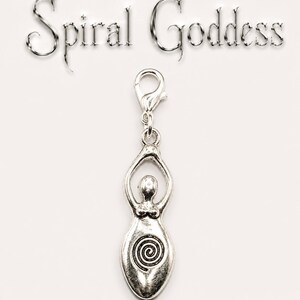 May include: A silver-colored charm with a goddess figure and a spiral design. The charm is attached to a clasp and has the words "Spiral Goddess" above it. The charm is likely made of metal and is on a white background.