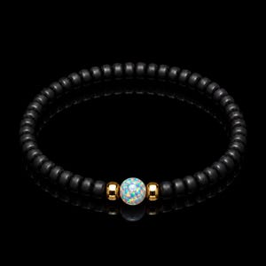 May include: A beaded bracelet featuring a series of small, matte black spherical beads. The center of the bracelet is accented by a single iridescent, multi-colored opal-style bead flanked by two polished, reflective gold-tone metal beads.