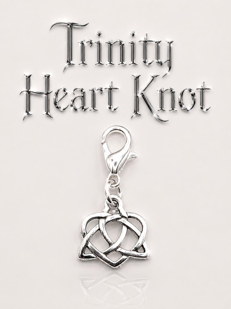 May include: A silver-colored charm with a Trinity Heart Knot design, suspended from a lobster clasp. The words "Trinity Heart Knot" are displayed in a metallic font above the charm on a white background.