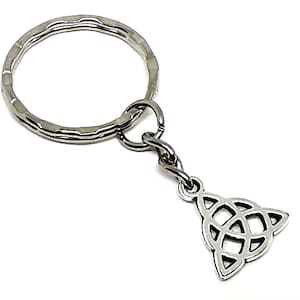 Könnte beinhalten: Ein silberfarbener Schlüsselanhänger mit einem keltischen Knoten-Anhänger. Der Schlüsselanhänger hat einen großen, strukturierten Ring und einen kleineren Ring, der mit dem Anhänger verbunden ist. Der Anhänger ist ein detailliertes, durchbrochenes keltisches Knotendesign.