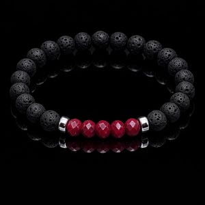 May include: A black lava stone bead bracelet with a central row of faceted red beads. The bracelet features a stretch design and silver-toned metal accents. The beads are round and have a textured surface.