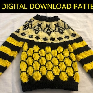 May include: A knitted sweater with a black and yellow honeycomb pattern and a yellow and black striped pattern on the sleeves. The sweater has a yellow and white yoke with a bee design.