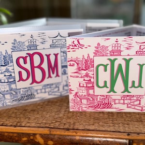 May include: Two decorative boxes with a toile pattern. One box features a blue and white design with pink initials "SBM", while the other has a pink and white design with green initials "CWJ". A list of values is visible.