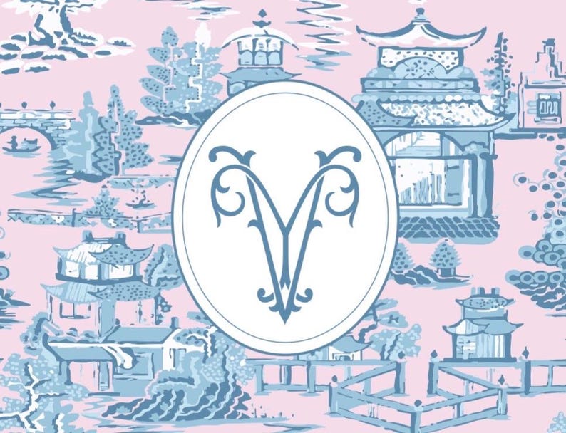 Op de afbeelding: Een roze en blauw toile-patroon met Aziatisch ge&iuml;nspireerde architectuur en landschappen. Een witte ovaal in het midden bevat de blauwe monogramletter "V". Geschikt voor behang, stof of decoratieve items.