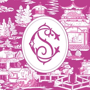 Op de afbeelding: Een magenta en wit toile-patroon met pagodes, bruggen en bomen. Een witte ovaal in het midden bevat een magenta monogram met de letters "S" en "C" verweven. Het ontwerp is een herhalend patroon.