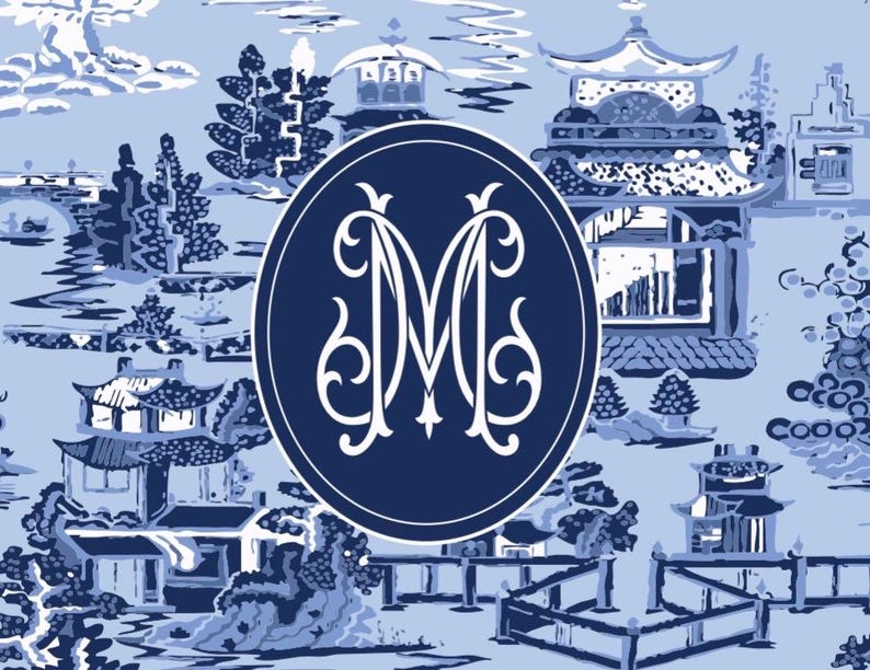 Op de afbeelding: Een blauw en wit toile de Jouy-patroon met pagodes, bomen en bruggen. Een marineblauw ovaal in het midden bevat de witte verweven letters "M" en "M". De achtergrond is lichtblauw.