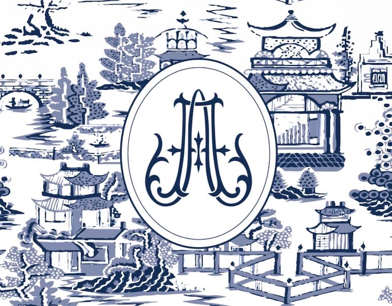 Op de afbeelding: Een blauw en wit toile de Jouy-patroon met een landschap met pagodes, bruggen en bomen. Een witte ovaal in het midden bevat de verweven letters "JA" in een donkerblauw, decoratief lettertype. Het ontwerp heeft een klassieke, elegante uitstraling.