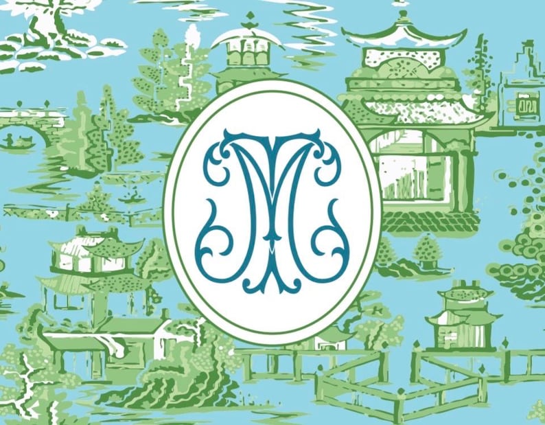 Op de afbeelding: Een lichtblauw en groen Chinoiserie-patroon met pagodes, bomen en bruggen. Een ovaal embleem met een turquoise "M"-monogram staat centraal. Het ontwerp doet denken aan traditionele Aziatische kunst.