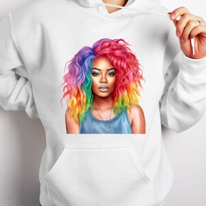 May include: A white hoodie with a colorful illustration of a woman with rainbow hair. The woman is wearing a blue tank top and a silver necklace.